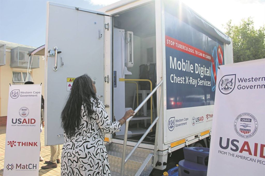 A patient walks up the the steps to enter the mobile digital chest x-ray service.