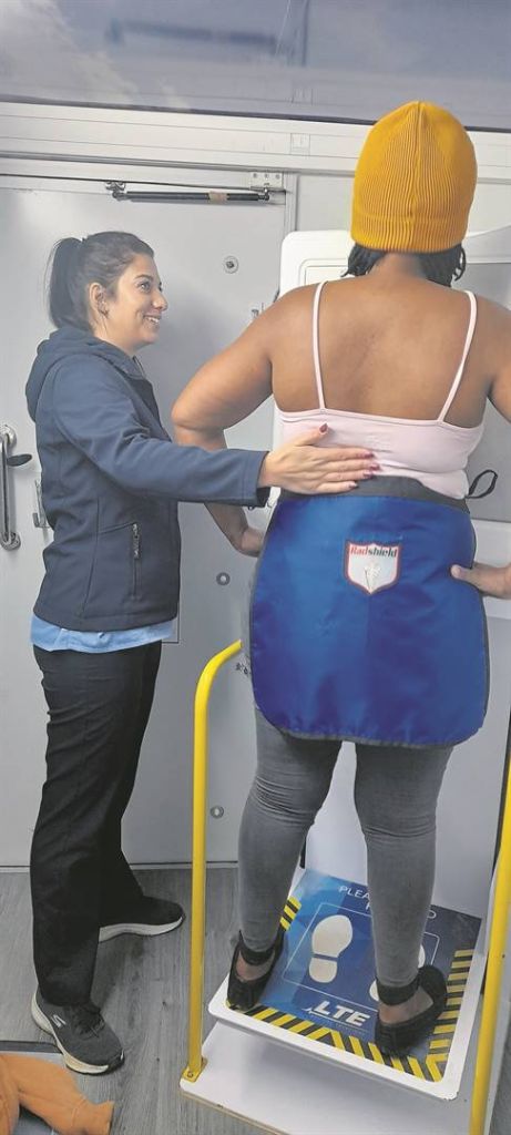 Inside the unit, radiographer Eunel Kleinhans shows a patient from Khayamandi what to do during a chest X-ray.